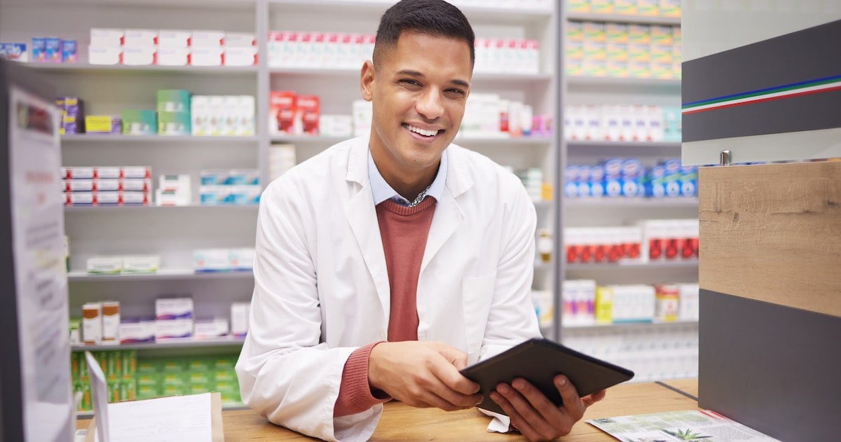 pharmacist giving a warm greeting to patient during over-the-counter transaction 