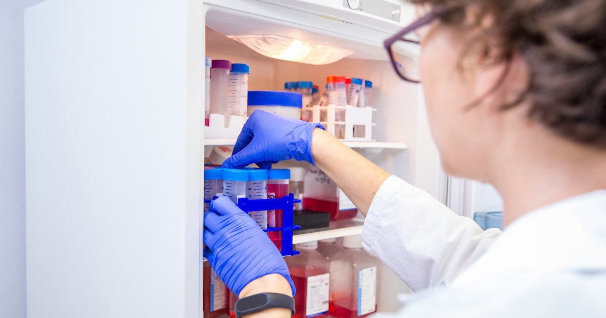 person reaching into a clinical research lab fridge 
