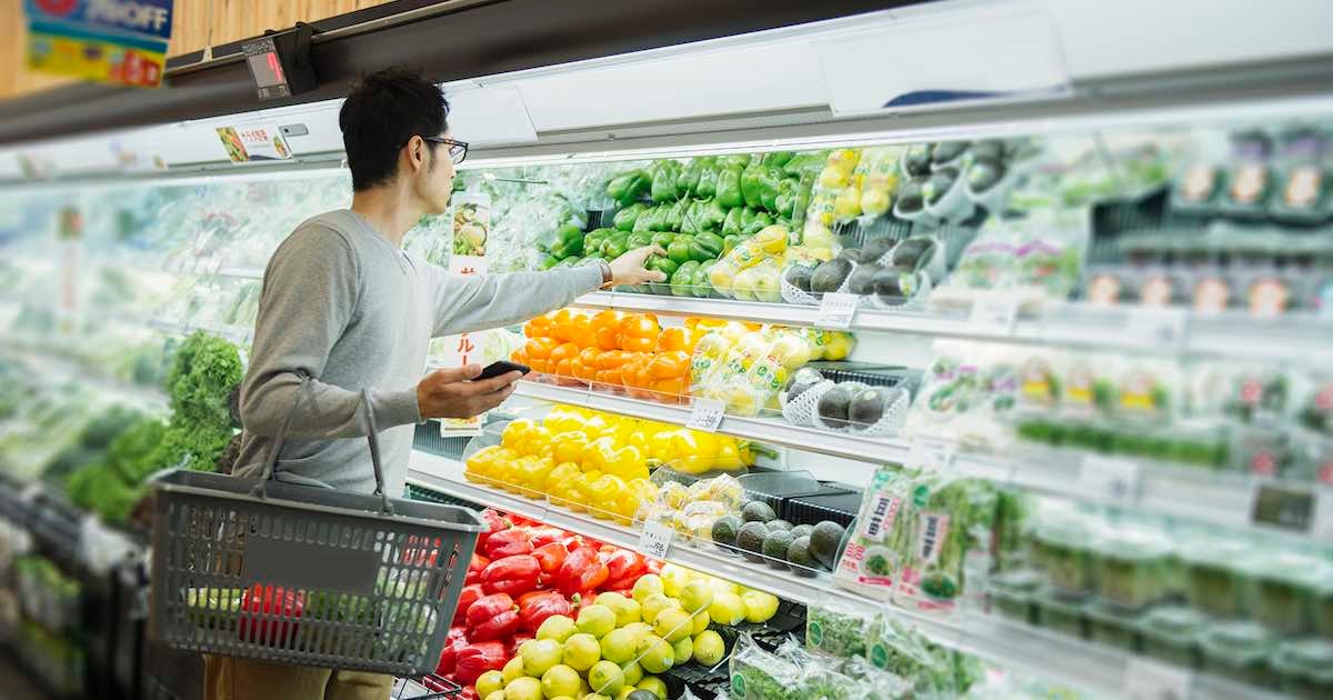 man selecting fresh produce in retail grocery store 