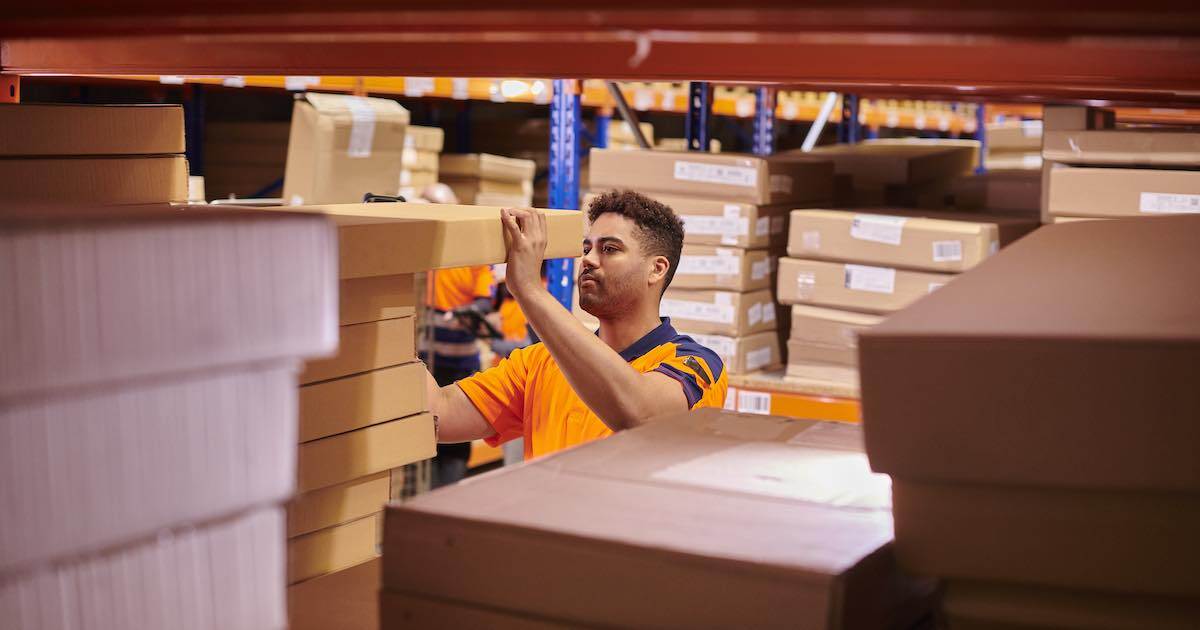 man taking a package off a shelf in a warehouse