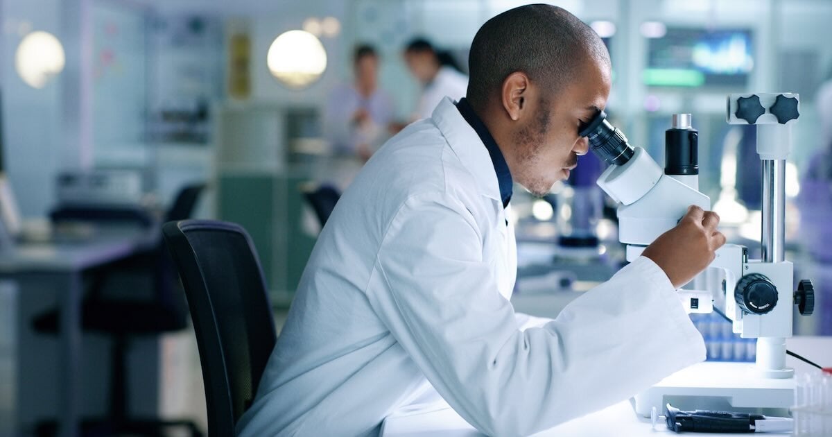clinical researcher looking into microscope