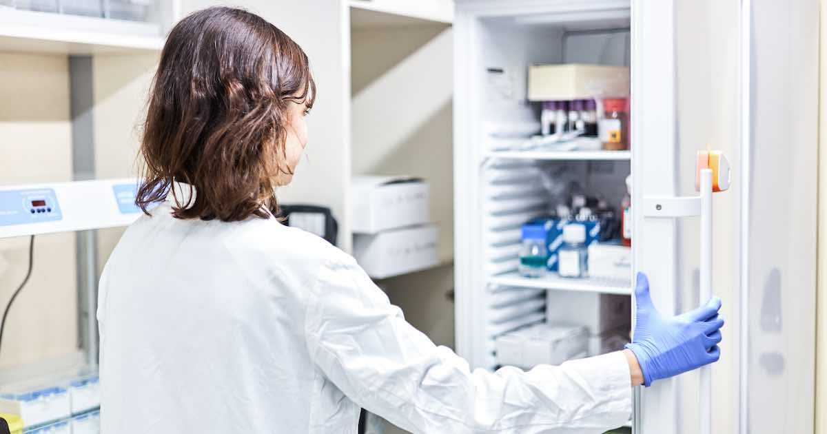 doctor looking into refrigerator with medical products in it