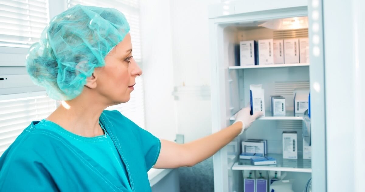 person working in a medical lab reaching into a freezer