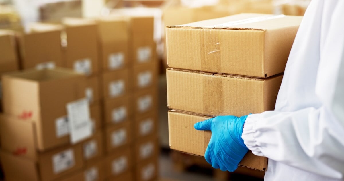 person holding boxes of medications in a warehouse