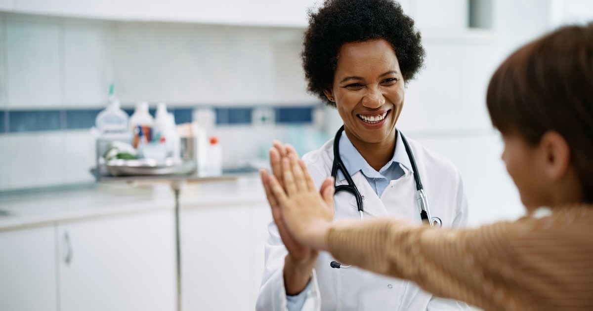 doctor interacts with child patient in an uplifting manner